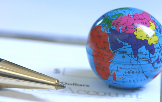 A small globe rests on a client’s account details document, representing seamless international event execution.