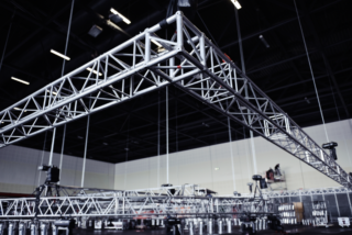 Steel truss rigging and power setup in a hotel conference hall, showing the framework and suspended equipment.