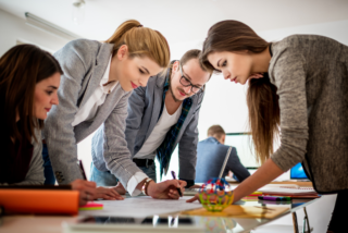 Team of young professionals collaborating on an event planning proposal.